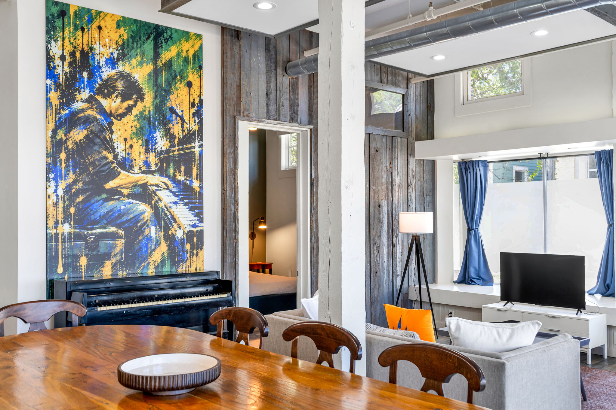 The dining table in the foreground with the mural and piano beyond in The Ivories suite