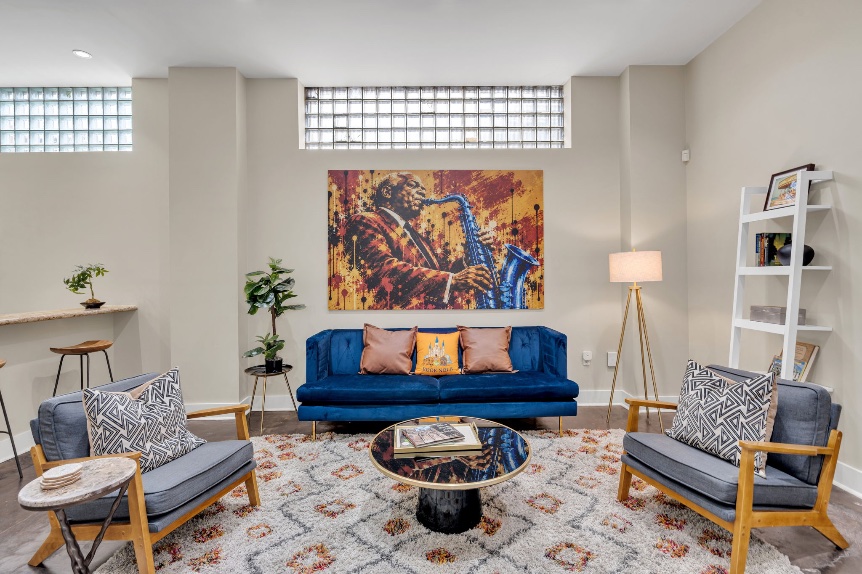 The Reed mural — a saxophonist leaning into a solo, above the blue velvet sofa in the main room