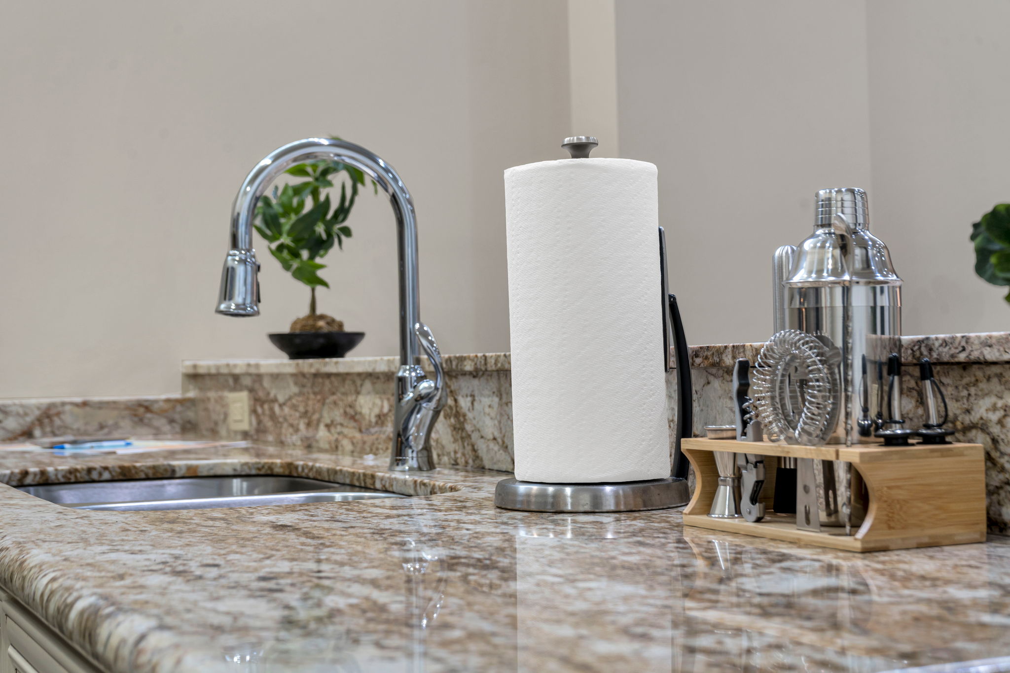 Kitchen counter close-up with the gooseneck faucet and cocktail bar tools in The Reed suite