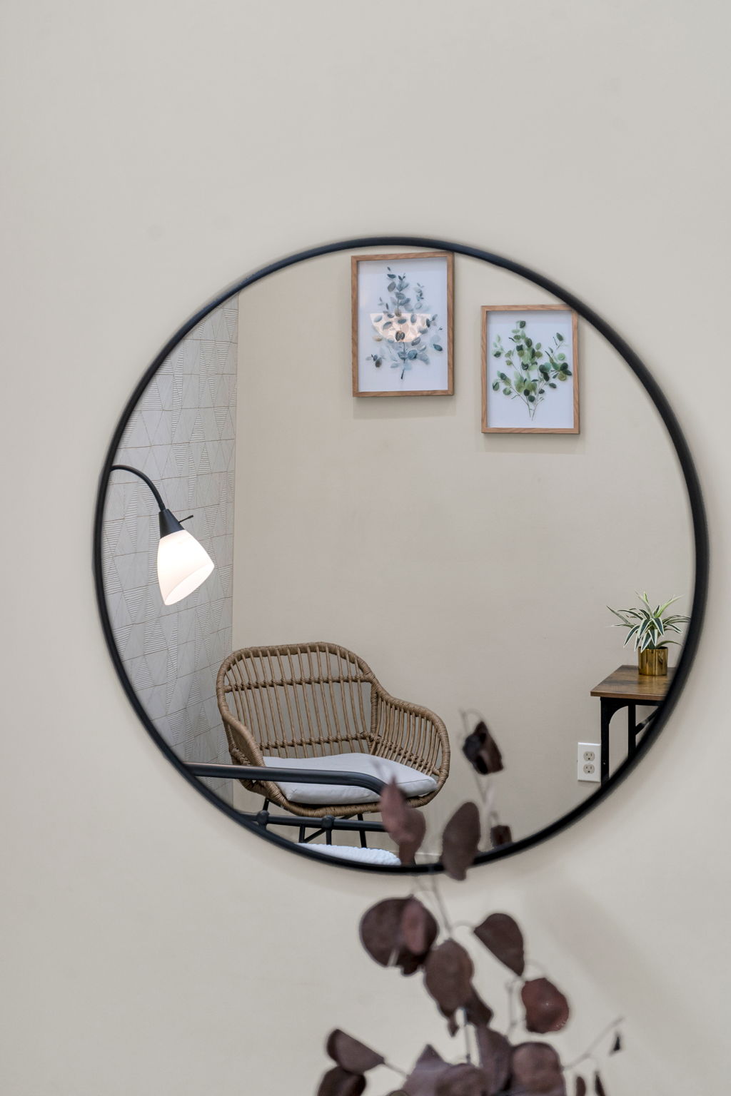 A round mirror reflecting a corner of The Reed suite