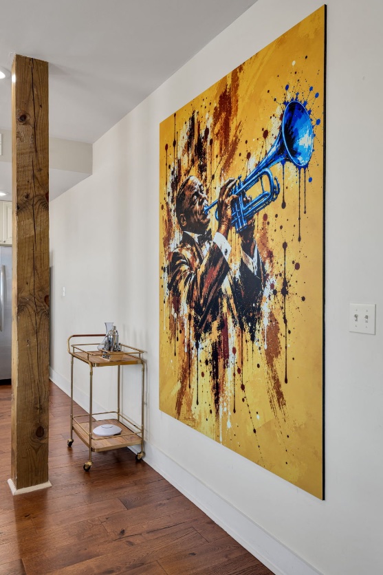 The Bell mural — Louis Armstrong raising a blue trumpet, painted in splashes of gold in the main room