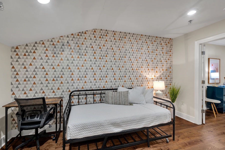 The extra daybed between the bedrooms in The Licorice suite, against the triangle-patterned wallpaper