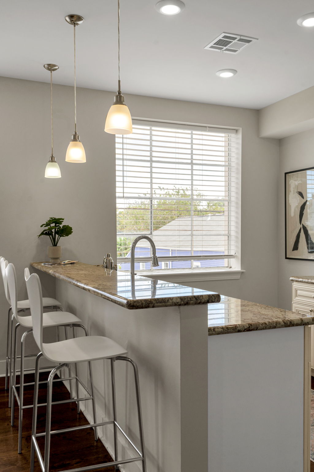 The kitchen breakfast bar in The Licorice suite — granite counter with white stools