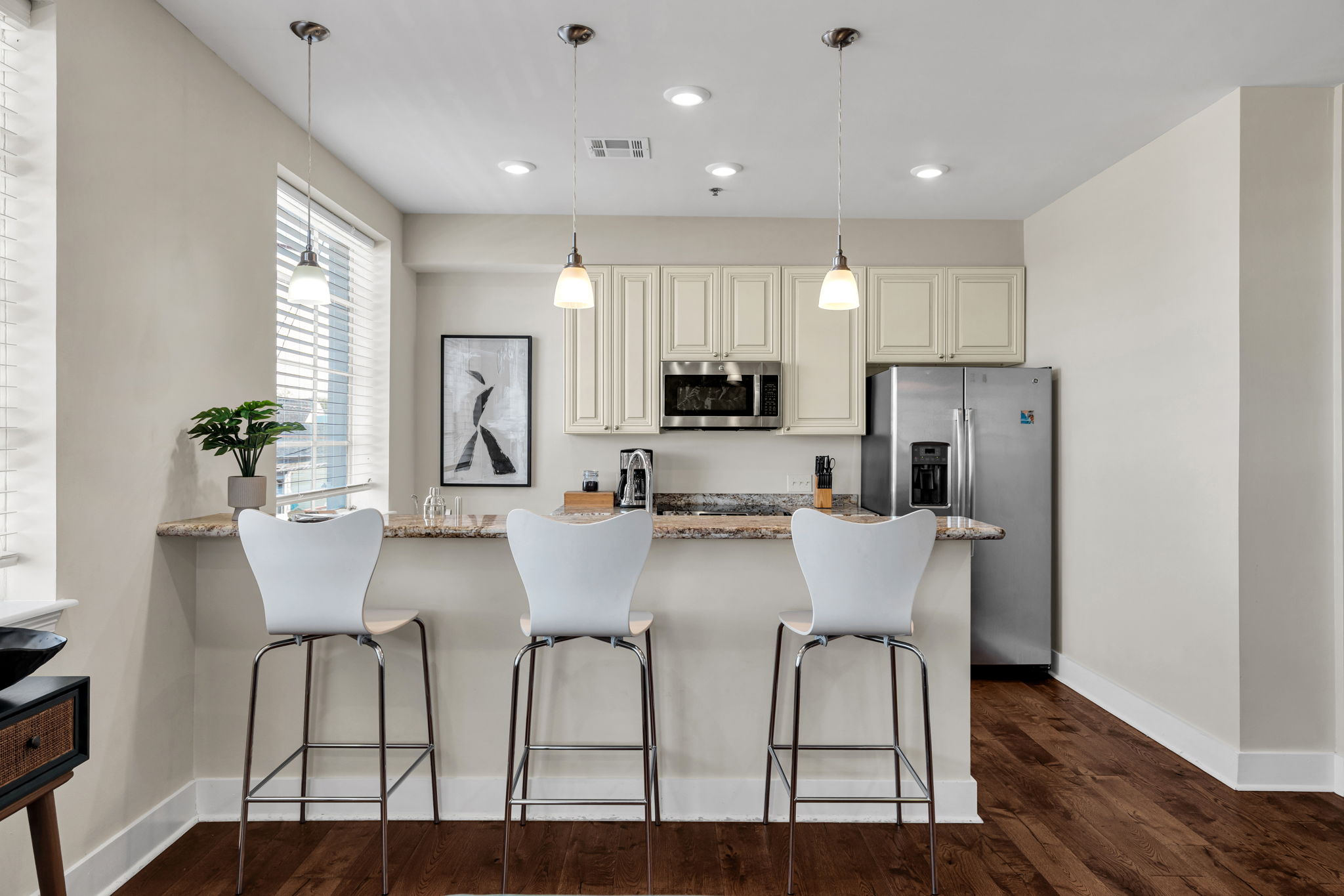 The kitchen in The Licorice suite — white chairs at the counter and a stainless fridge