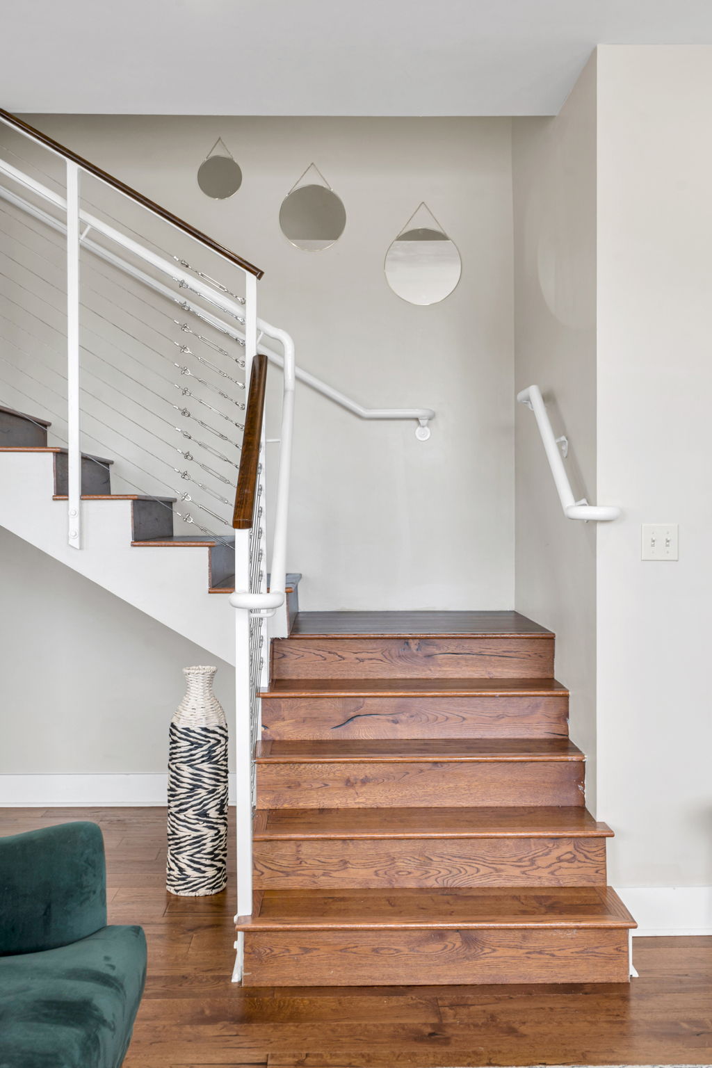 The wooden staircase in The Licorice suite, with round mirrors on the wall