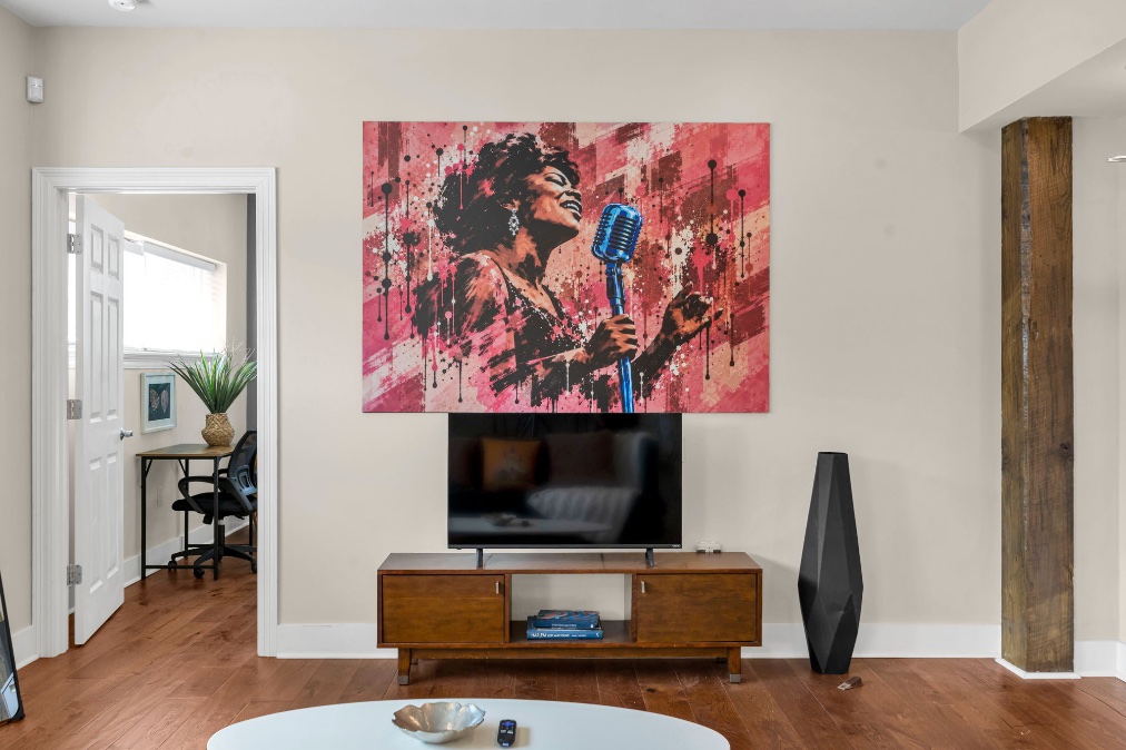 The Soul mural — Irma Thomas singing, painted in splashes of gold, green, and blue above the TV in the main room