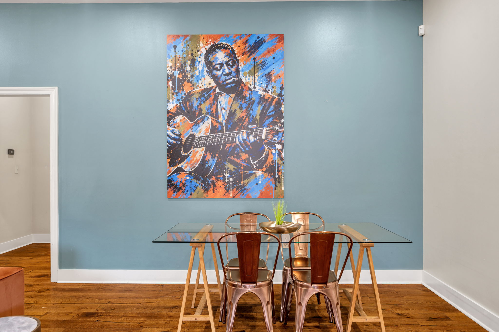 The Lonnie Johnson mural straight on, above the glass dining table on the blue wall in The Delta suite