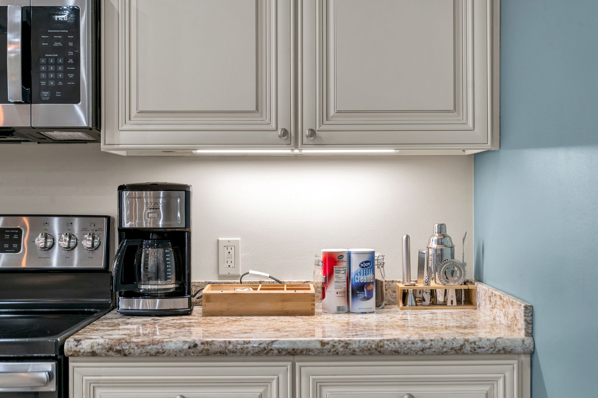 The kitchen counter in The Delta suite — coffee maker, coffee creamer, and cocktail bar tools