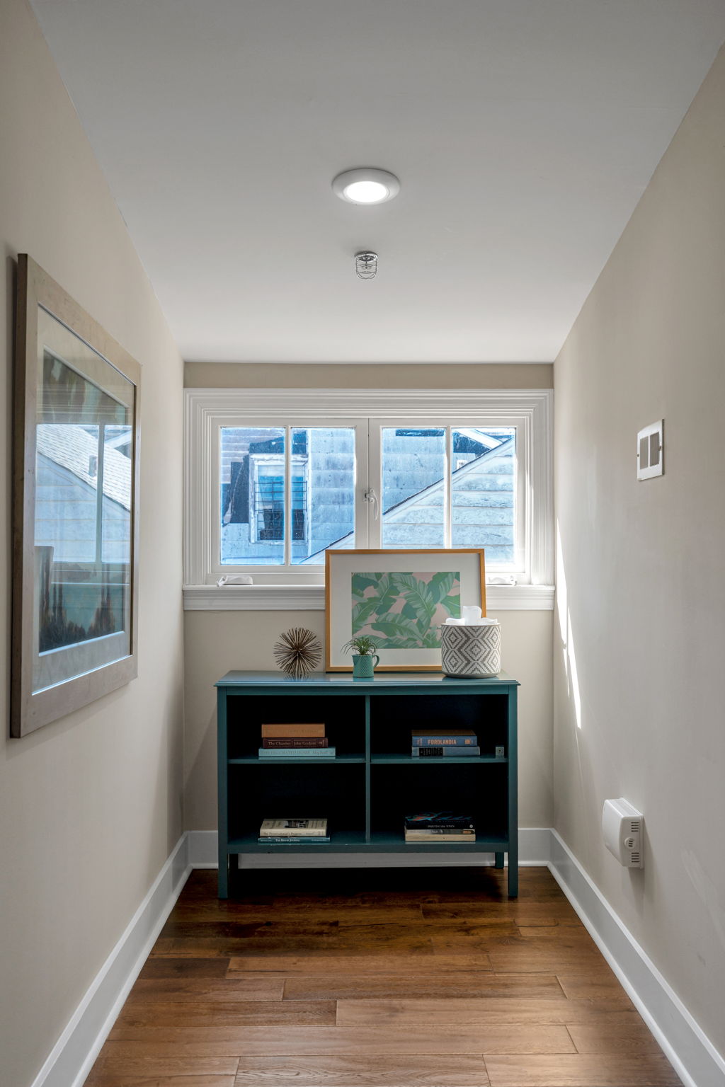 The hallway nook in The Delta suite — teal bookcase under the window
