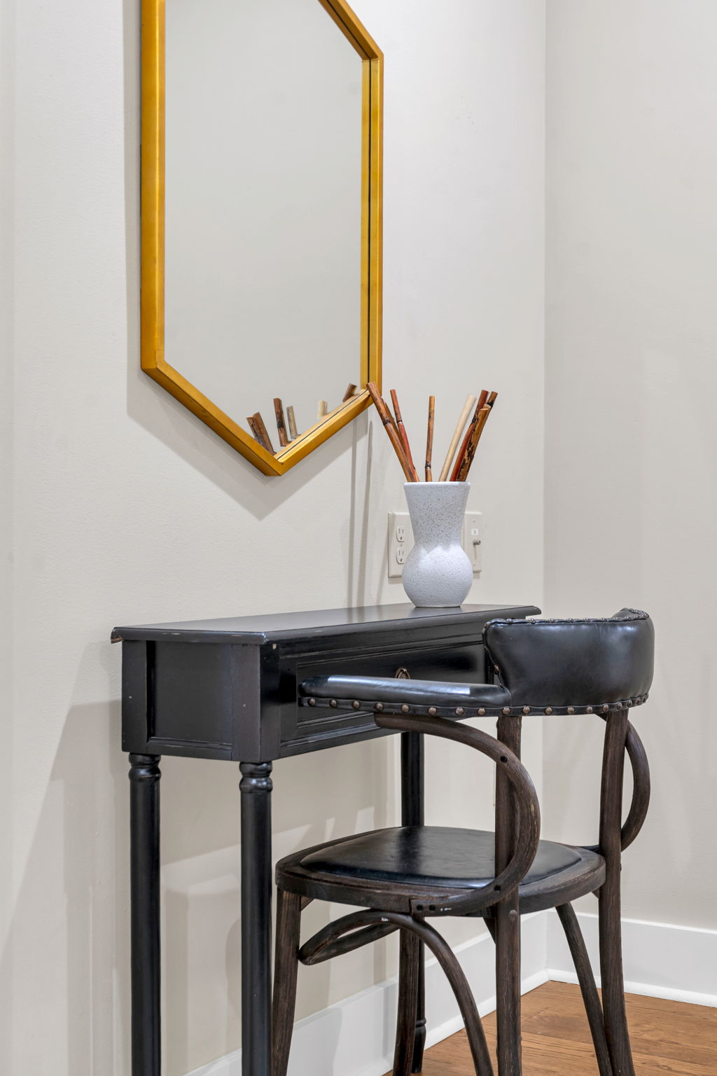 The black vanity desk with gold-framed mirror and bentwood chair in The Delta suite